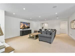 Streeter built lower level family room, television, flatscreen, sound bar, carpet, hockey jersey in display case