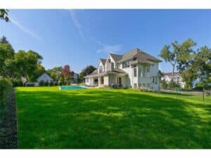 Side yard of Streeter Built Home with green grass and pool at Lakeview Avenue Deephaven