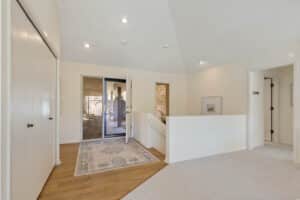 Foyer with wood floors and vaulted ceiling.