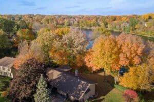 Aerial of home one lake with green yard on sunny day